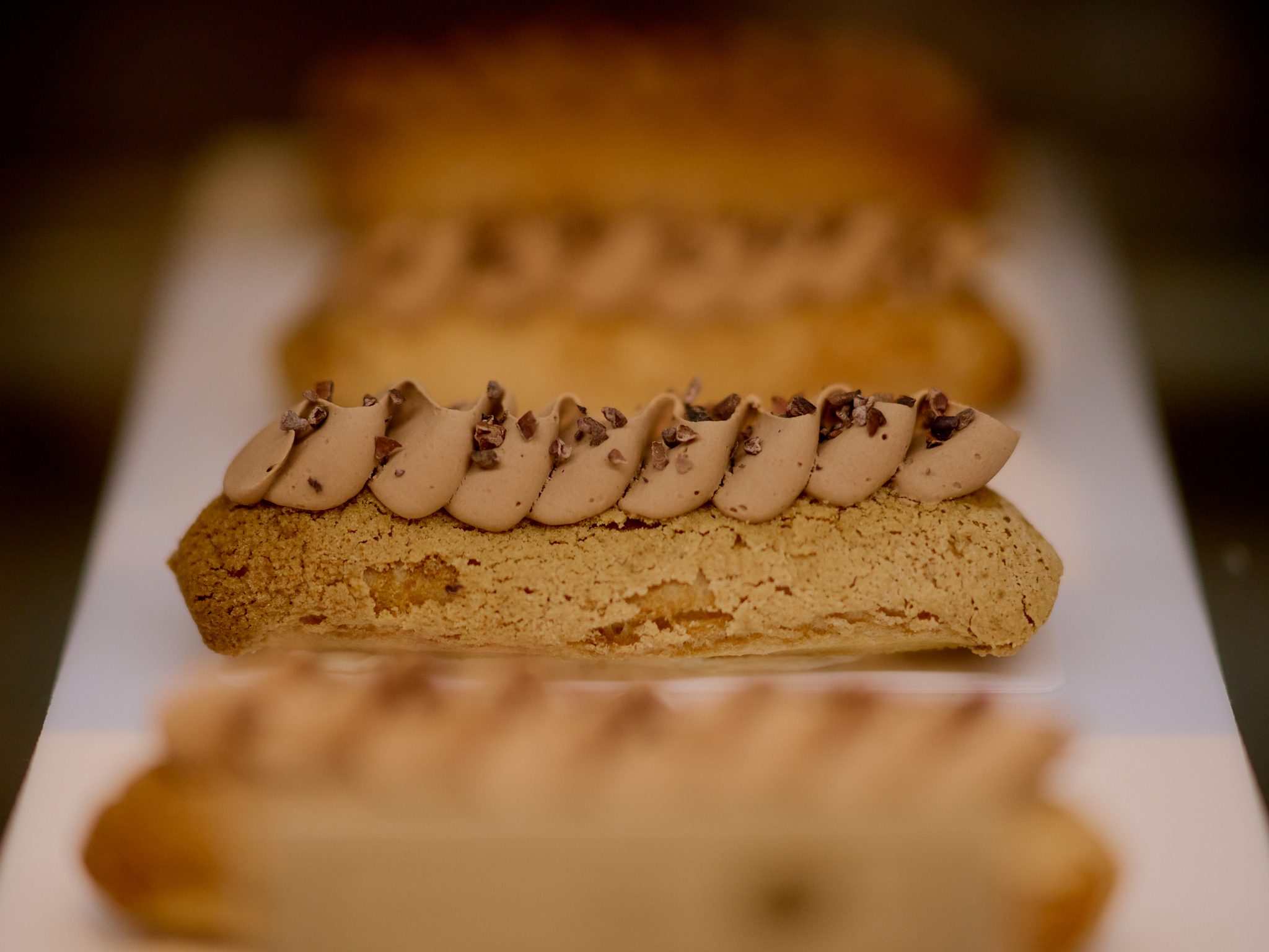 Glazed éclair on a dark plate