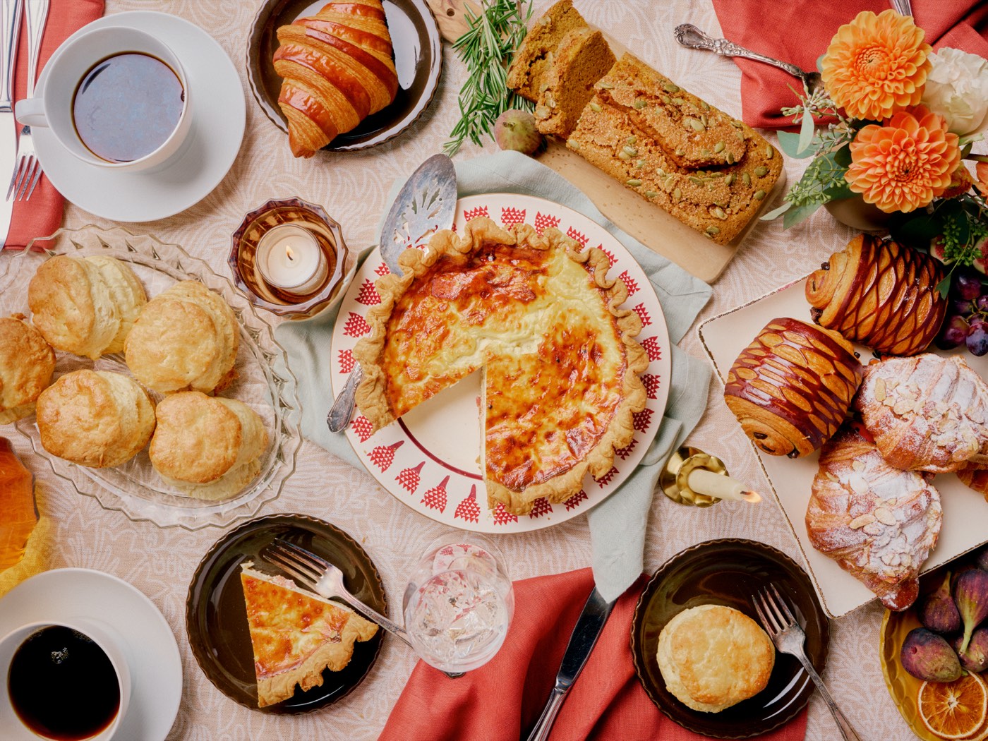 An overhead spread of Copain holiday baking — quiche, seasonal pies, croissants, and biscuits