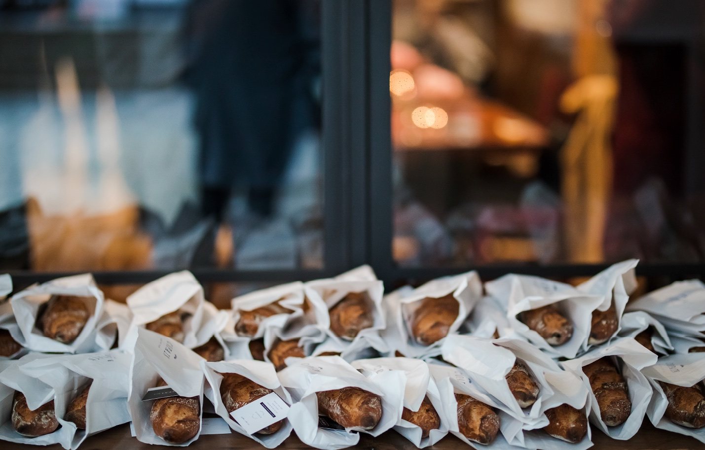 Rows of individually wrapped croissants lined up on a windowsill